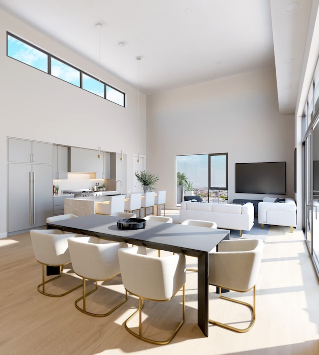 dining room with light wood-type flooring and a towering ceiling