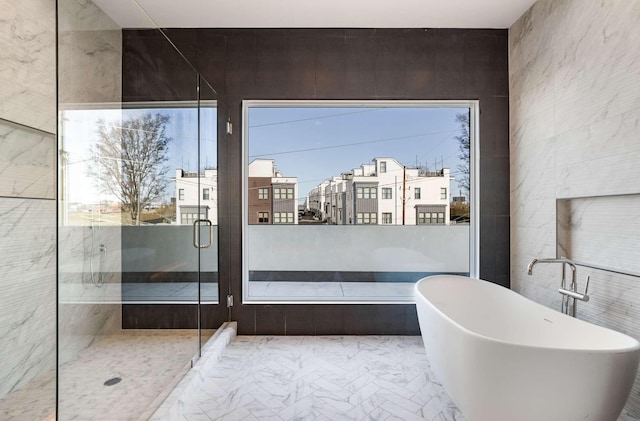 full bathroom with a freestanding tub, tile walls, and a stall shower