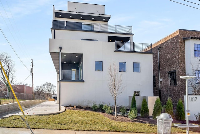 view of home's exterior with stucco siding and fence