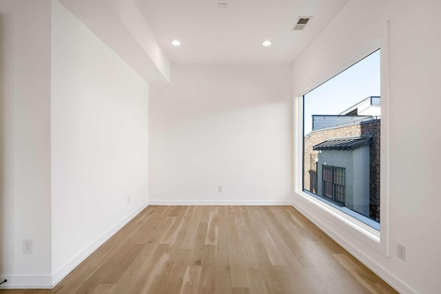 unfurnished room with visible vents, baseboards, recessed lighting, a fireplace, and light wood-type flooring