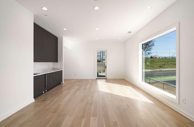 unfurnished living room featuring recessed lighting, baseboards, and light wood-style floors