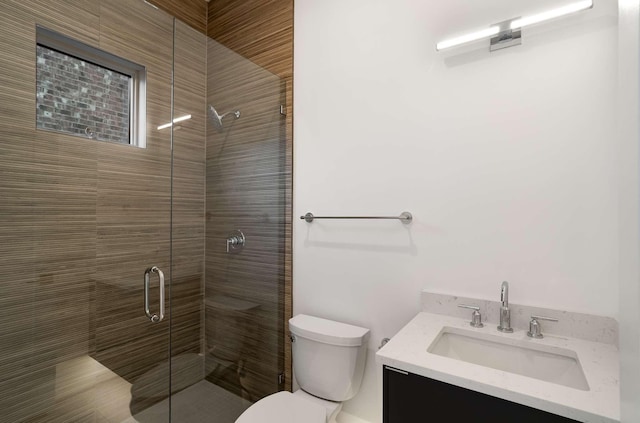 full bathroom featuring a stall shower, toilet, and vanity