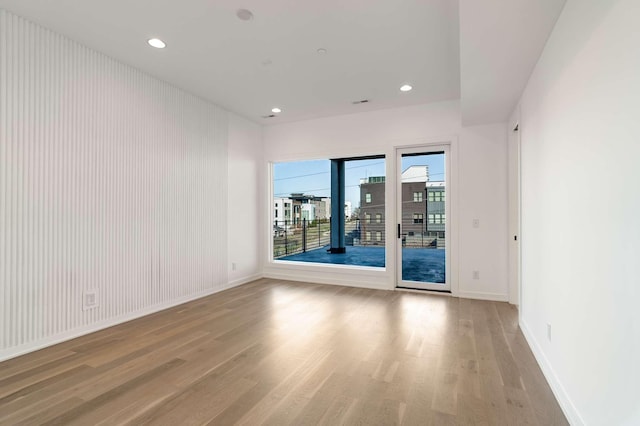 empty room featuring recessed lighting, baseboards, and light wood-type flooring