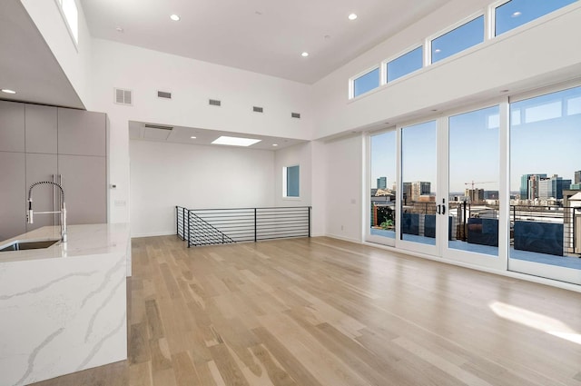 spare room featuring a sink, visible vents, a city view, and light wood-style flooring