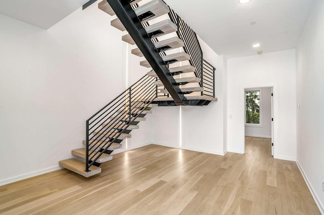 stairs with recessed lighting, baseboards, and wood finished floors