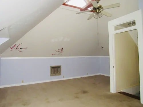 additional living space with carpet floors, lofted ceiling with skylight, and ceiling fan