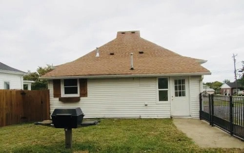 rear view of property featuring a lawn