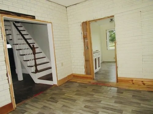 basement with dark wood-type flooring and brick wall