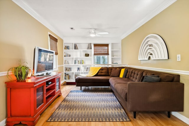 living room featuring wood-type flooring, ornamental molding, and ceiling fan