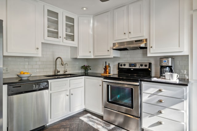 kitchen featuring white cabinetry, dark parquet floors, appliances with stainless steel finishes, and sink