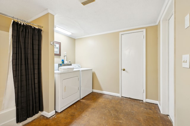 laundry room featuring a textured ceiling, ornamental molding, and washing machine and clothes dryer