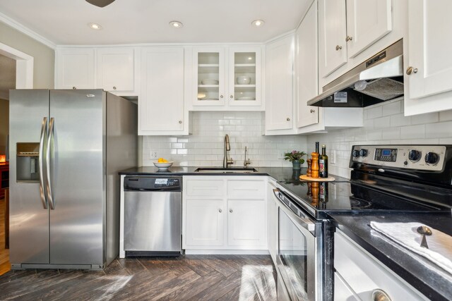 kitchen featuring dark parquet floors, appliances with stainless steel finishes, sink, and white cabinetry