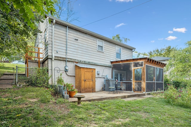 back of property with a sunroom, a yard, and a patio area