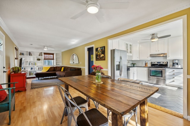 dining space with light wood-type flooring and ornamental molding