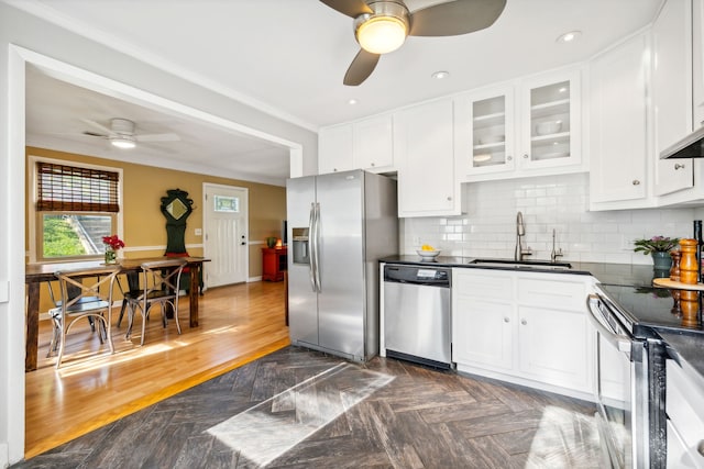 kitchen with sink, white cabinets, decorative backsplash, stainless steel appliances, and crown molding