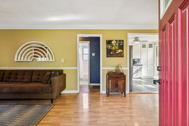 living room featuring crown molding, ceiling fan, and light hardwood / wood-style flooring