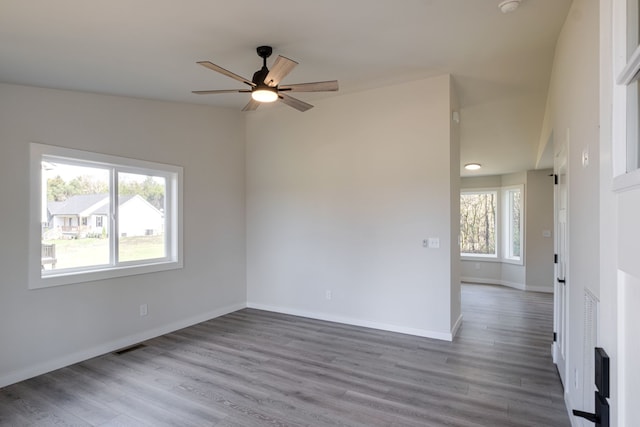 empty room with ceiling fan, a healthy amount of sunlight, and light hardwood / wood-style flooring