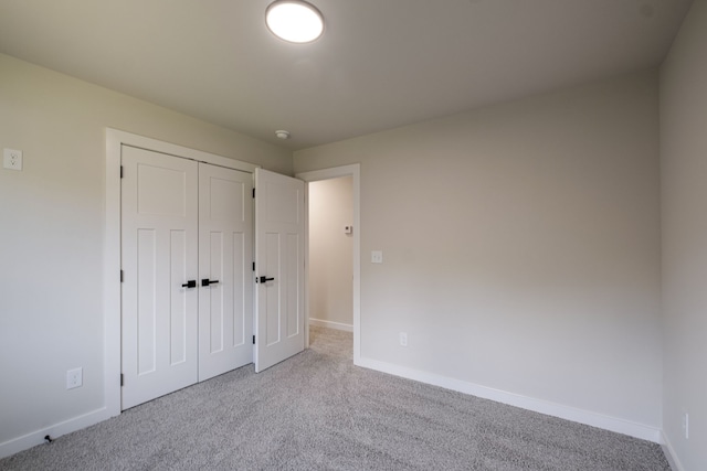 unfurnished bedroom with light carpet and a closet