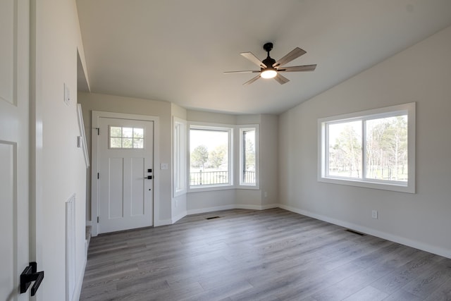 foyer entrance featuring ceiling fan, light hardwood / wood-style floors, and vaulted ceiling