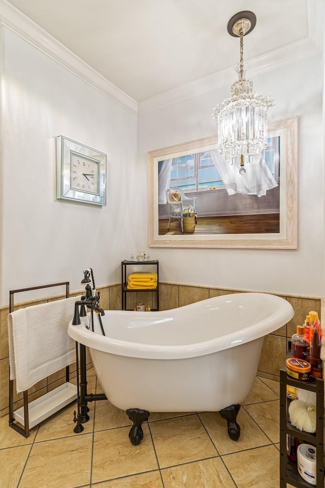 bathroom with tile patterned floors, wooden walls, ornamental molding, a notable chandelier, and a bathing tub