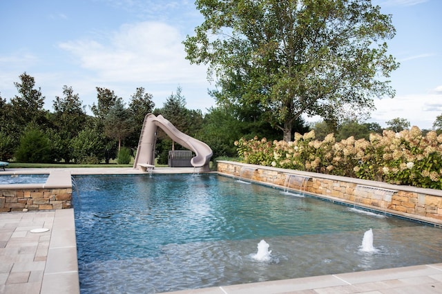 view of swimming pool featuring a jacuzzi, a patio, a water slide, and pool water feature