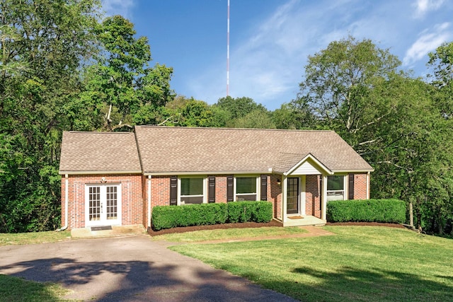 ranch-style home featuring french doors and a front lawn