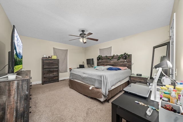 bedroom with a textured ceiling, light colored carpet, and ceiling fan