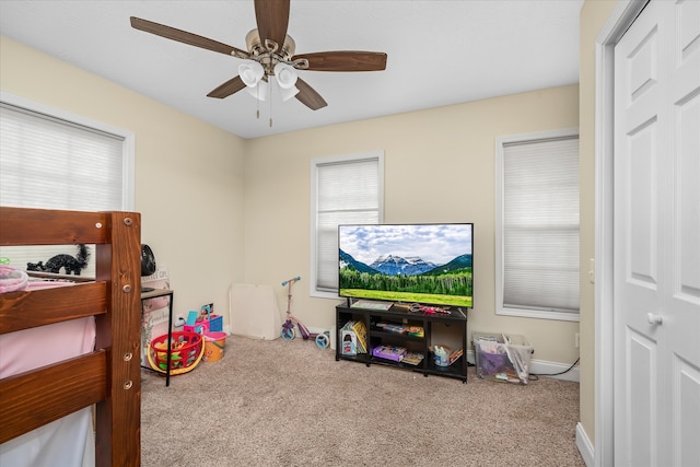 carpeted bedroom featuring ceiling fan and multiple windows