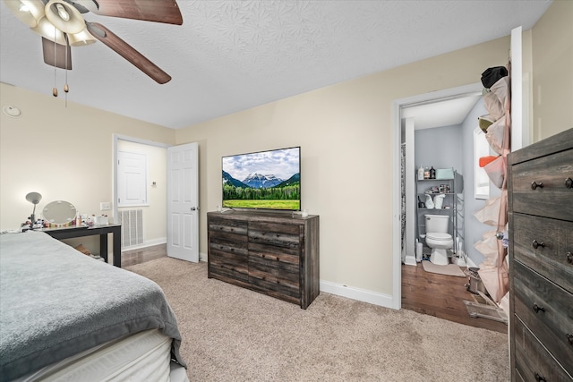 carpeted bedroom featuring connected bathroom, ceiling fan, and a textured ceiling