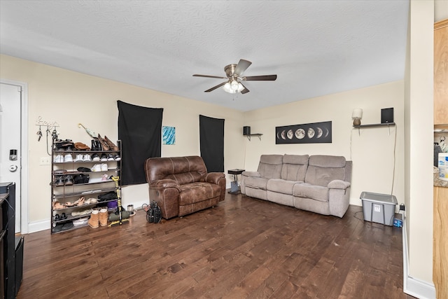 living room featuring dark hardwood / wood-style floors, a textured ceiling, and ceiling fan