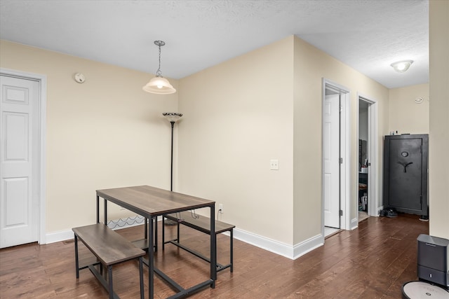 dining room with a textured ceiling and dark hardwood / wood-style floors