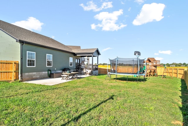 view of yard with a trampoline and a patio area