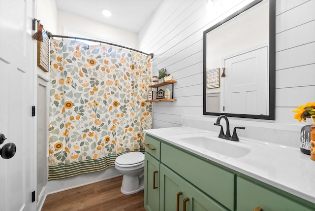 full bathroom with wooden walls, vanity, hardwood / wood-style flooring, shower / bath combo, and toilet