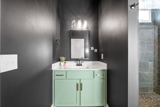 bathroom with tiled shower and vanity