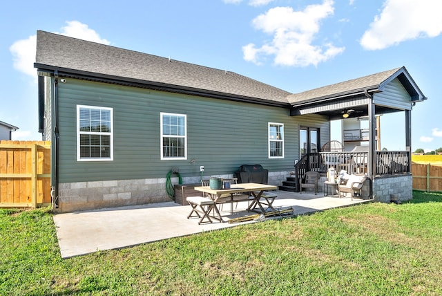 back of property with ceiling fan, a lawn, and a patio area