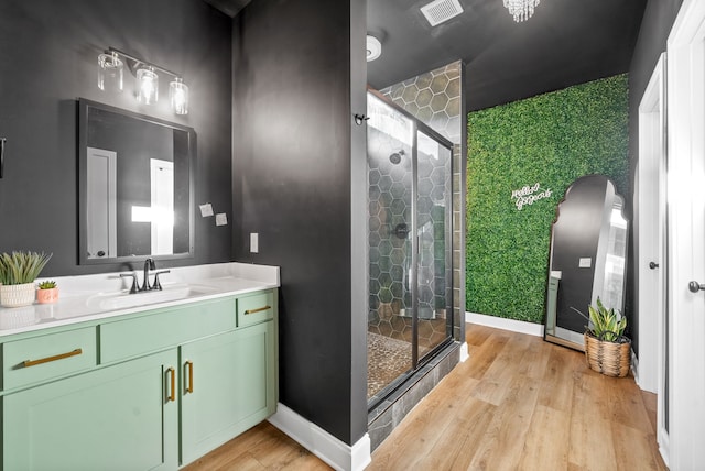 bathroom with vanity, a shower with shower door, and hardwood / wood-style flooring