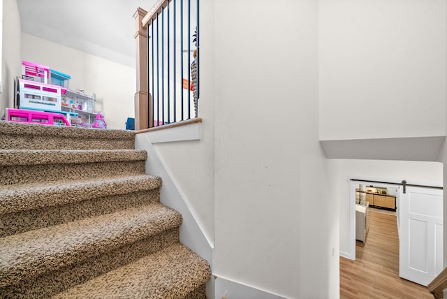 stairway featuring hardwood / wood-style flooring and a barn door