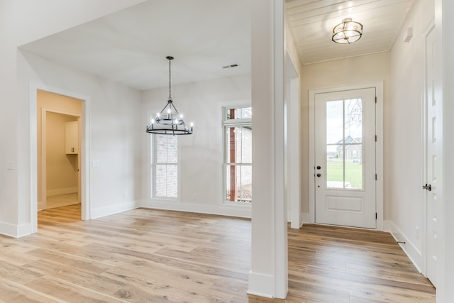 entryway with light wood-type flooring, wood ceiling, and an inviting chandelier