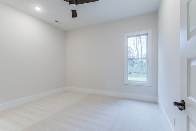 spare room with ceiling fan and light colored carpet