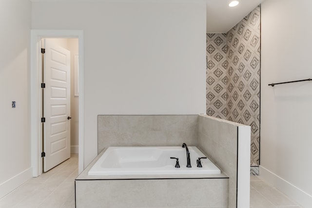 bathroom with tile patterned floors and a relaxing tiled tub