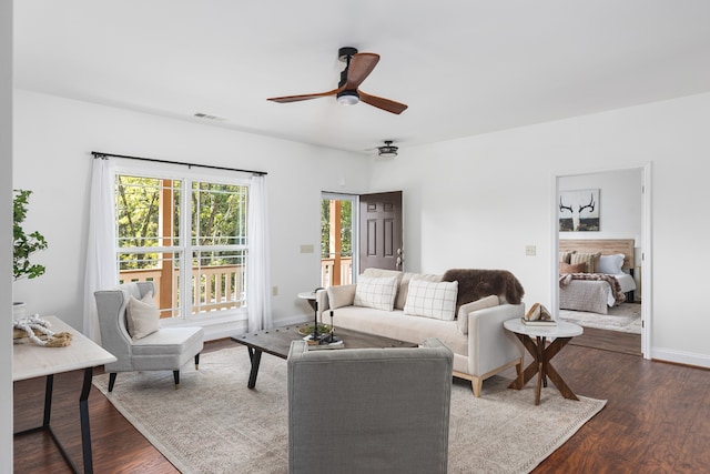 living room with ceiling fan and dark hardwood / wood-style flooring