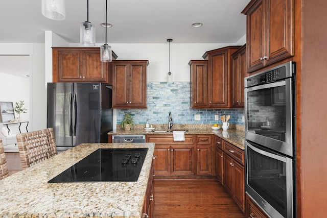 kitchen featuring pendant lighting, sink, stainless steel appliances, and dark wood-type flooring