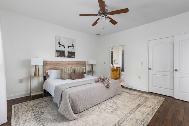 bedroom with ceiling fan, ensuite bath, and dark wood-type flooring