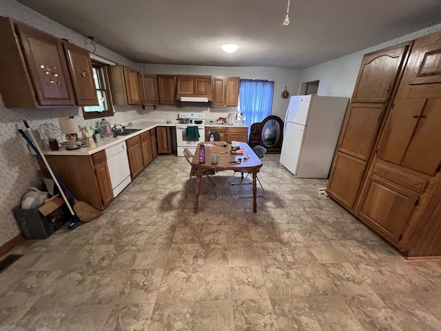 kitchen with white appliances, a textured ceiling, and sink