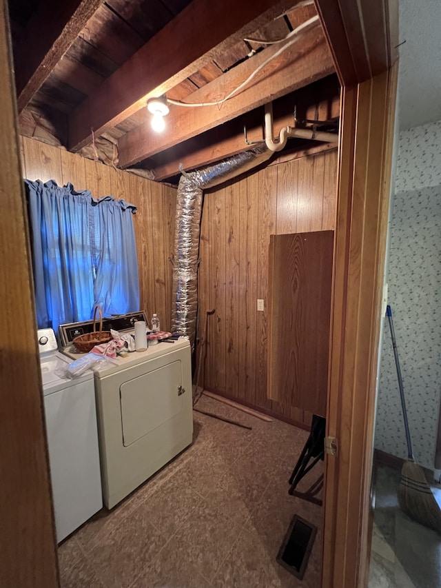 laundry room with wooden ceiling, washing machine and dryer, and wood walls