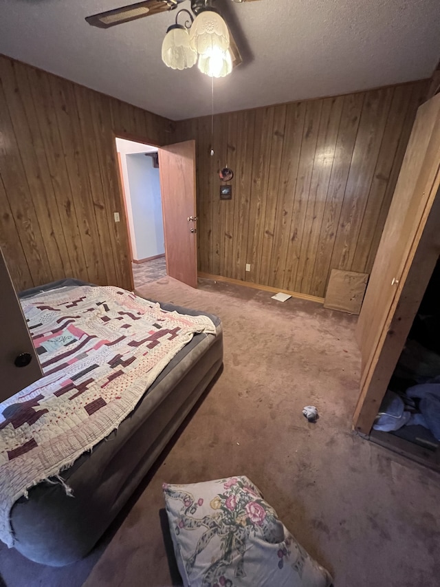 bedroom with carpet flooring, wood walls, and ceiling fan