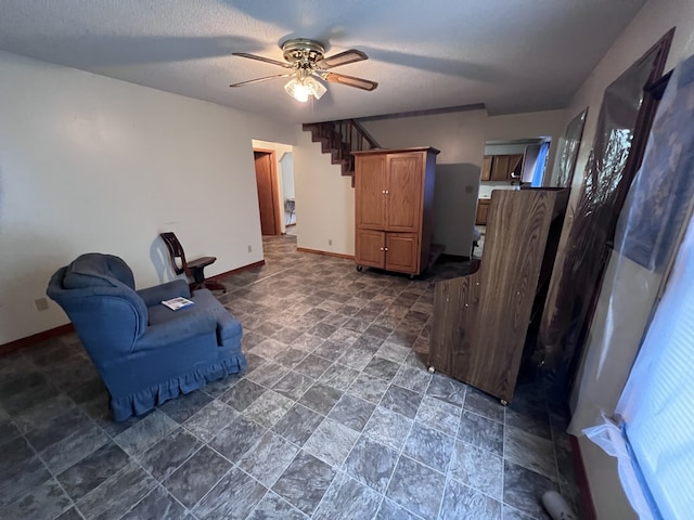 sitting room with ceiling fan and a textured ceiling