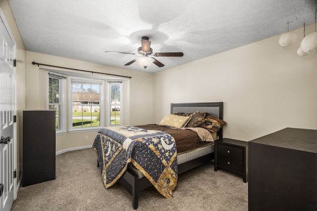 carpeted bedroom with ceiling fan and a textured ceiling