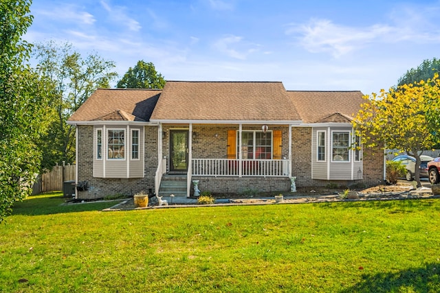 ranch-style home featuring covered porch and a front yard