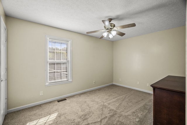 unfurnished room featuring carpet floors, a textured ceiling, and ceiling fan